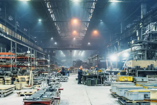 A fully operational factory floor with automated production lines and workers monitoring equipment.